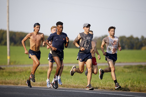Justyn Knight (blue shirt), pictured during cross country season, broke his own Syracuse record in the 1500-meter run on Friday night.