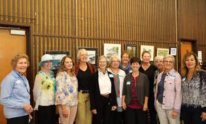A group of artists pose for a picture in front of their work hanging at the Onondaga Art Guild.